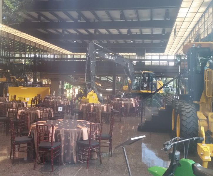 A corporate event being hosted indoors with John Deere Equipment being present. 