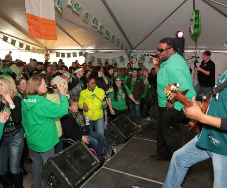 A St. Patricks Day Celebration event with a large gathering of individuals enjoying a live band.