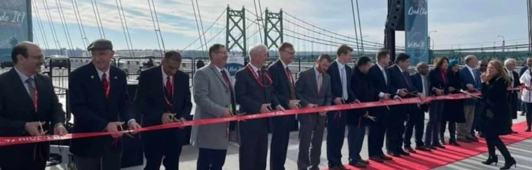 A government event being held outside on a new bridge.