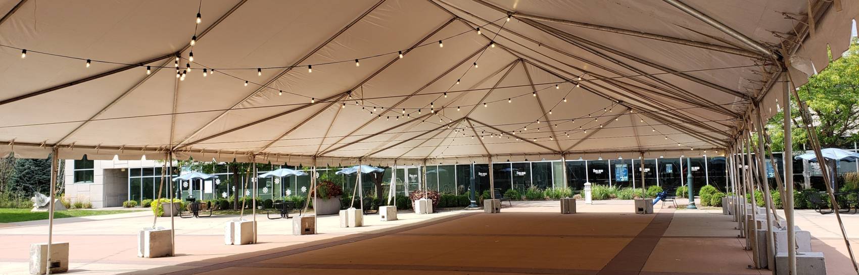 A tent outside being decorated and set up for a wedding event.