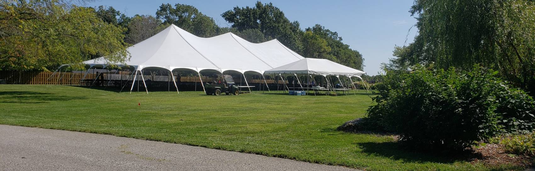 An outside tent set up in a lush green landscape.
