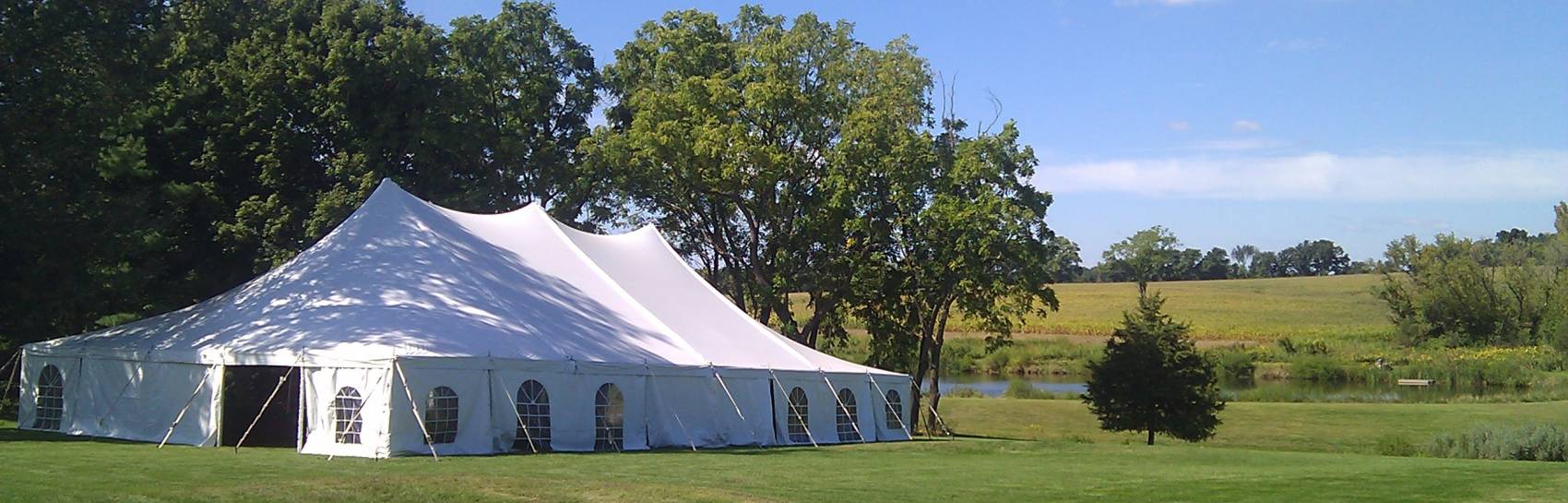 An outdoor tent with windows ready for an event with a bright blue sky above.