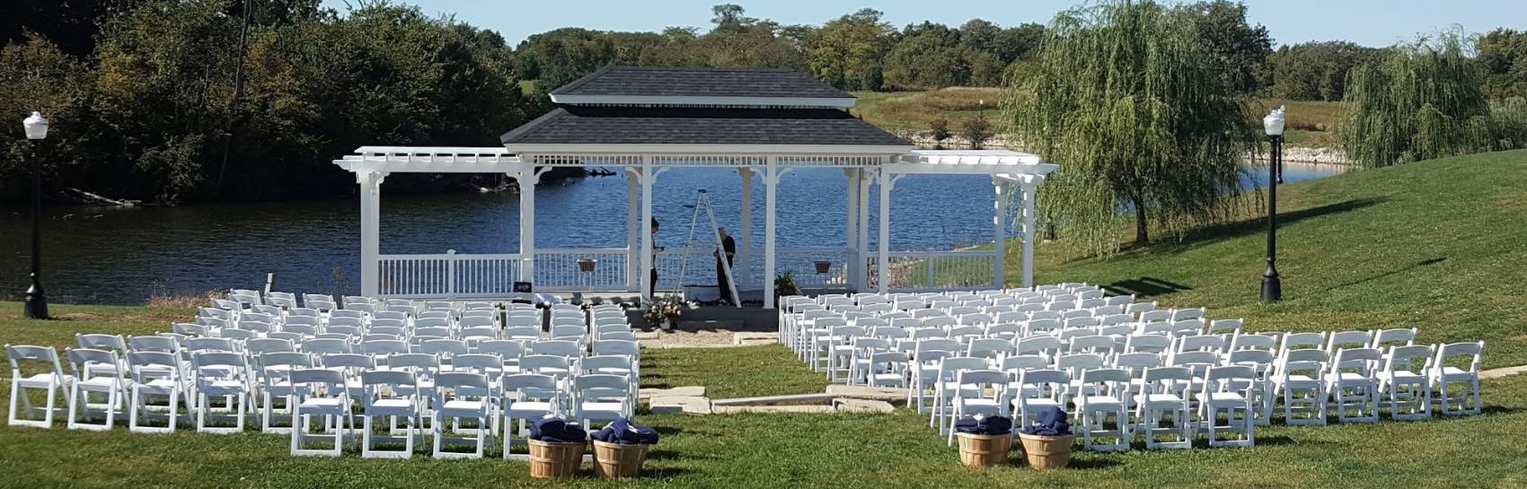 An outdoor event made for a large gathering with the seating facing the lake.