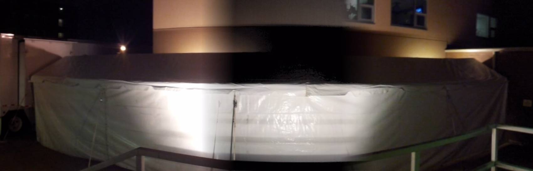 An outdoor image of a tent being set up for a corporate event.