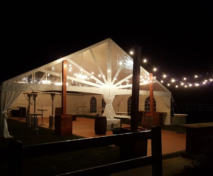 A tent lit up in the night for a wedding event.